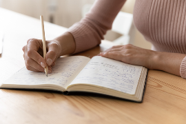 Woman writing down notes in a book